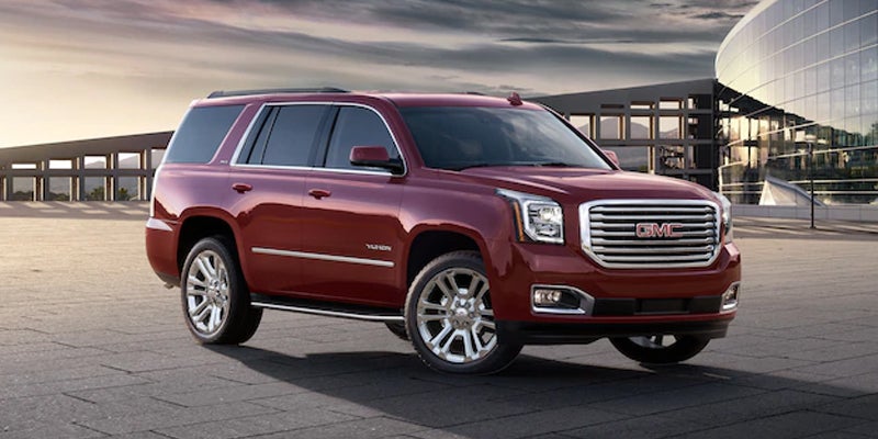 red 2019 GMC Yukon, shown in a side profile, highlighting its sleek design and bold features.