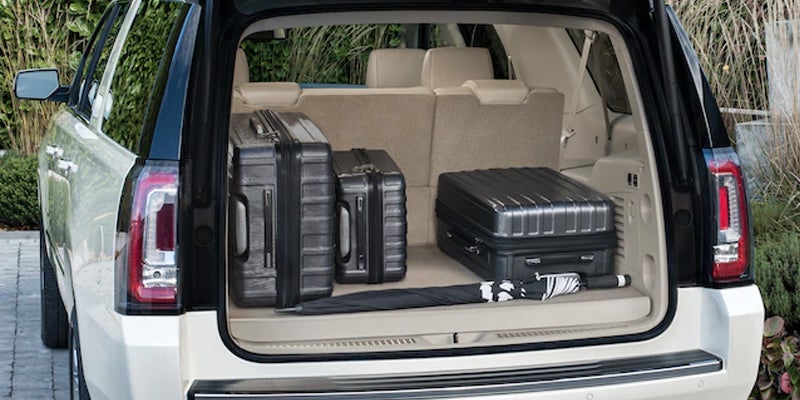 The trunk of a 2019 GMC Yukon with three bags inside.