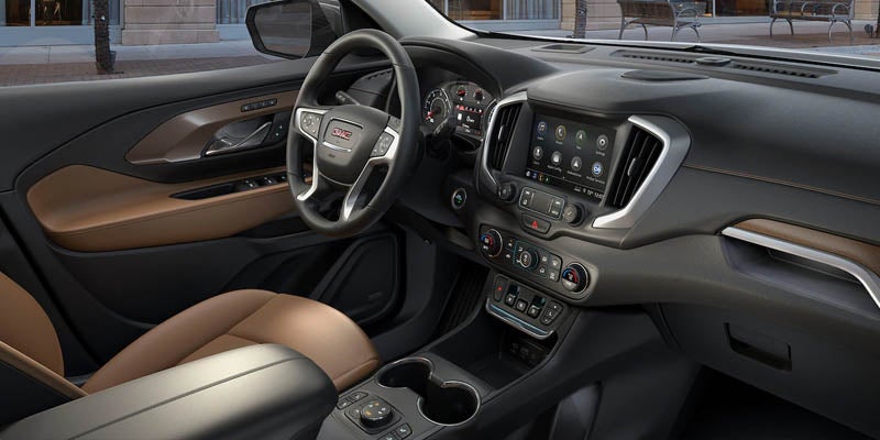 The interior of a GMC Terrain, featuring the steering wheel, front cabin, and dashboard controls.