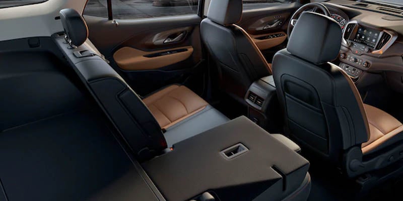 The rear seat of a GMC Terrain folded down, showcasing the interior space and storage area.